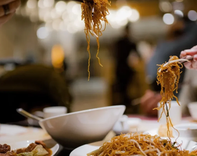 Teller und Schüsseln gefüllt mit Chinesischen Speisen.